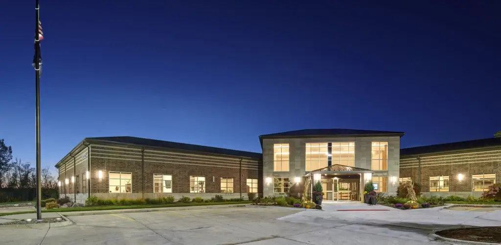 Lights shine outside the Wright Service Corp. headquarters building at dawn.