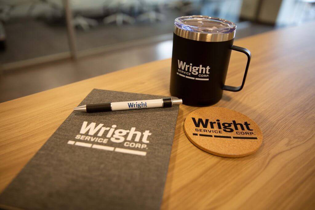 Wright Service Corp. new hire gifts of a notebook, pen, mug and coaster.